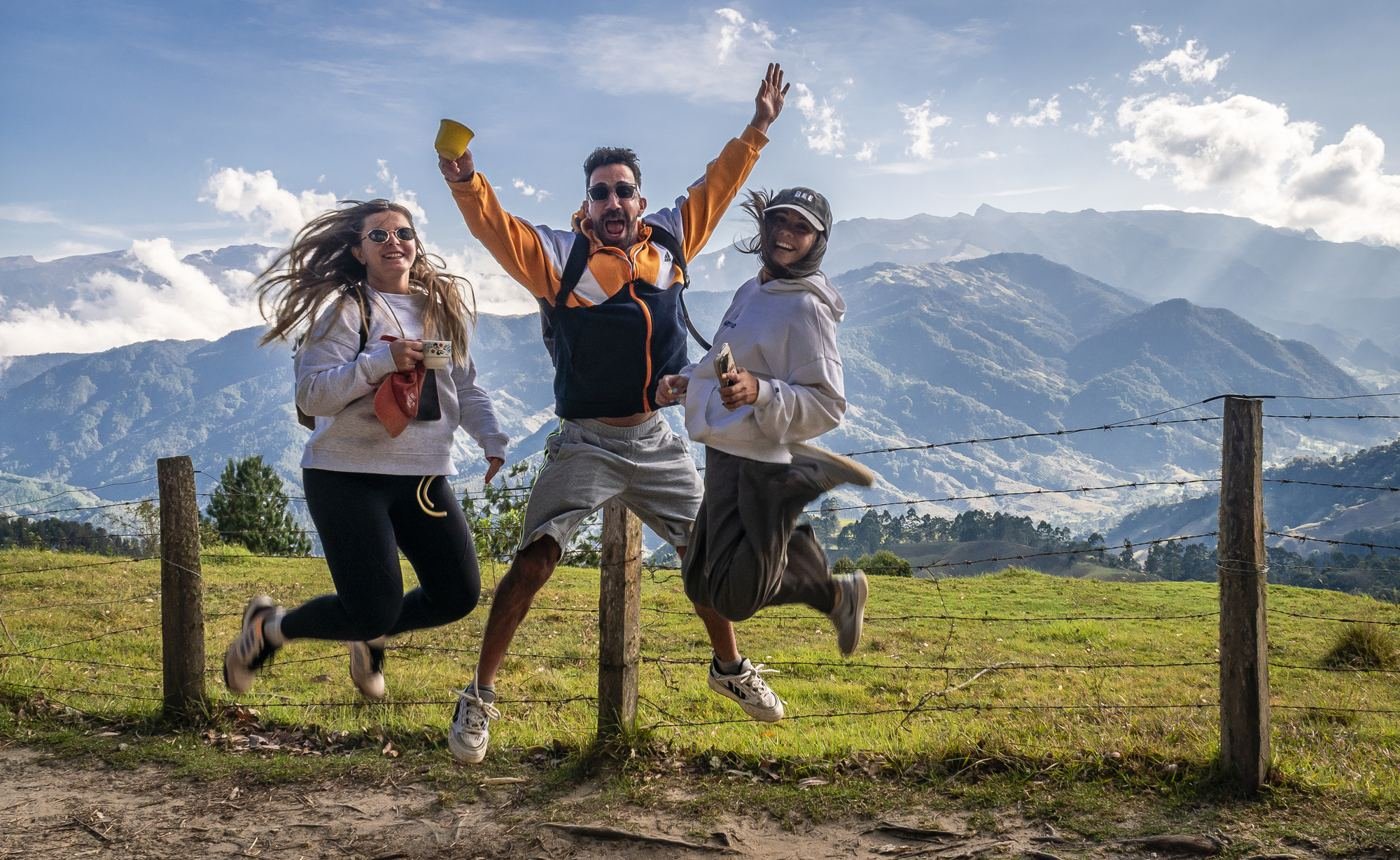 Viajeros saltando felices frente a las montañas de los Andes